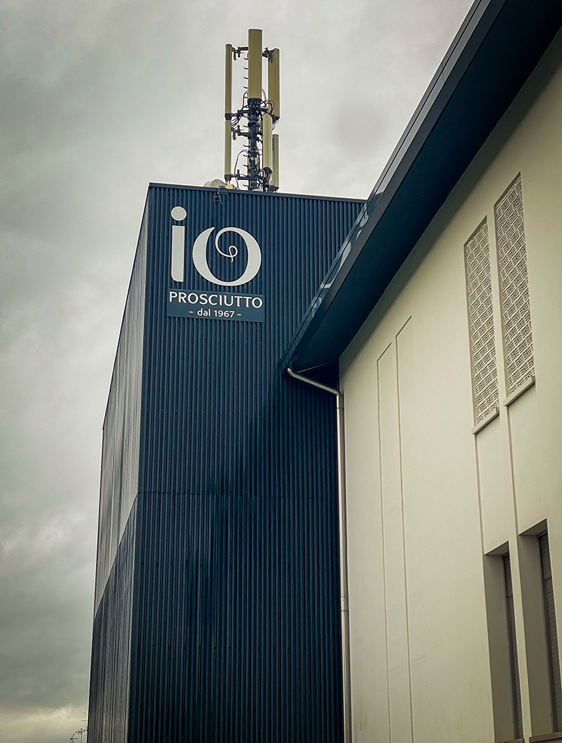 Edificio blu con insegna bianca Io Prosciutto.