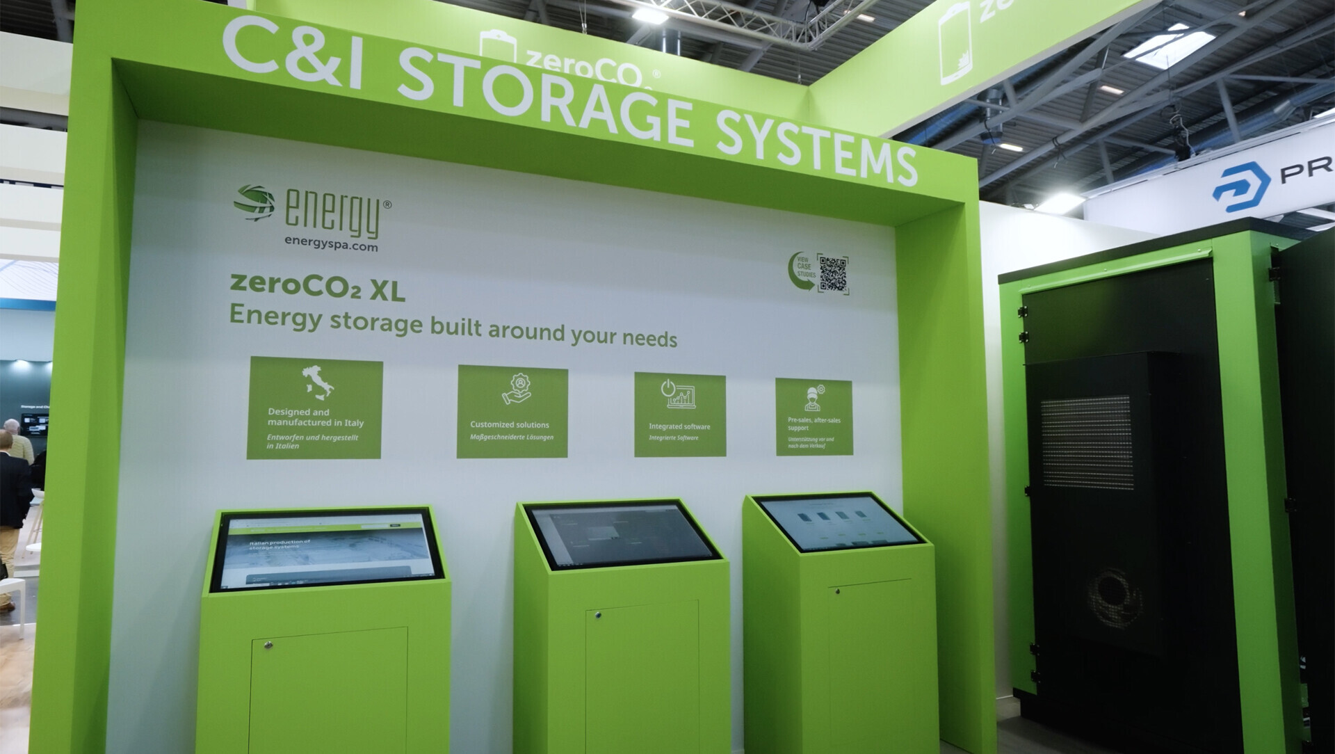 Stand Energy con sistema di accumulo zeroCO2 XL per uso industriale, tre schermi informativi e unità fisica, con info su produzione italiana e supporto tecnico.